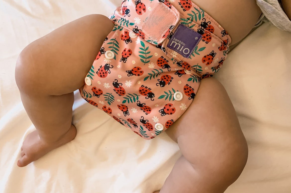 baby wearing an all-in-one cloth diaper