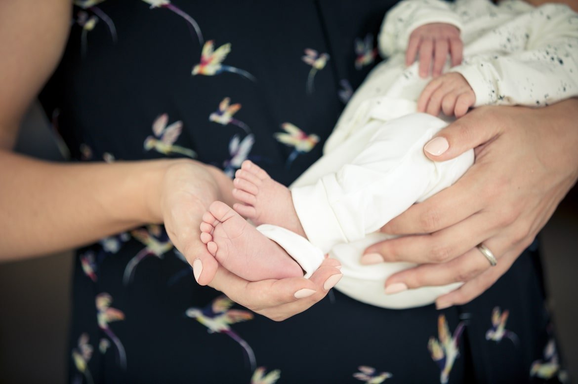 Mother holding the feet of a newborn baby