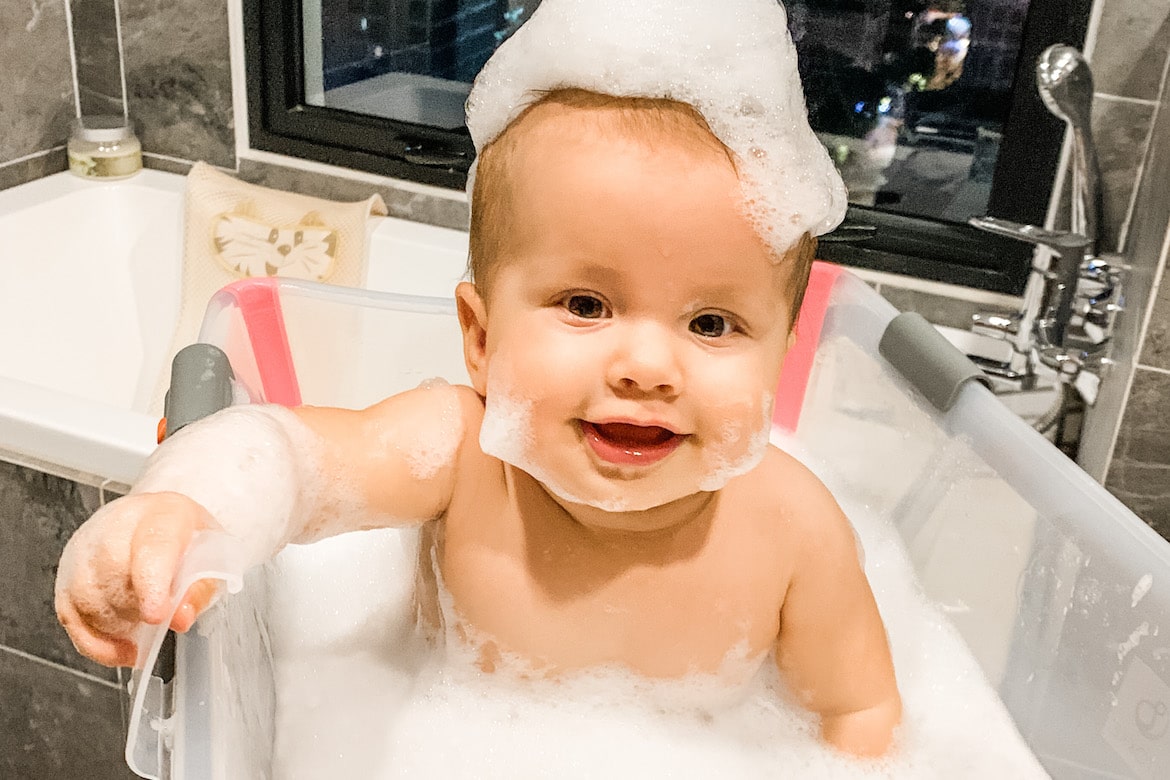 baby having fun while bathing in a Stokke Flexi Bath - A Cheeky Little Monkey